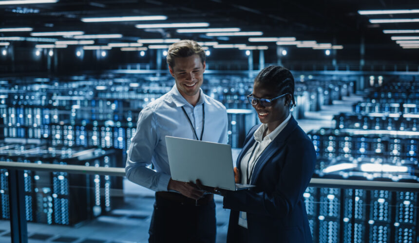 Corredores de Data Center, um homem e uma mulher olhando para o computador, trabalhando